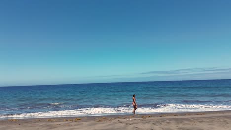 Idyllic-scene-of-a-woman-relaxing-unwinding-at-unspoiled-virgin-beach-in-Gran-Canaria,-Spain-during-summer-time-on-vacations