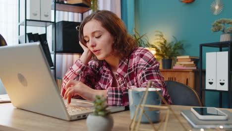 Gelangweilte,-Schläfrige-Geschäftsfrau-Arbeitet-Am-Laptop-Und-Gähnt,-Während-Sie-Sich-Am-Schreibtisch-Im-Homeoffice-Auf-Die-Hand-Stützt