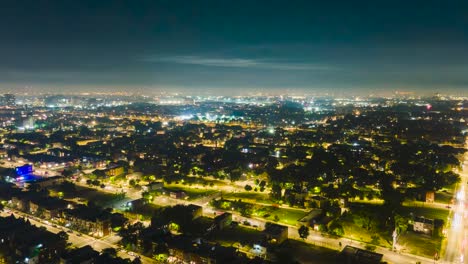 Aerial-hyper-lapse-drone-view-of-a-vibrant-cityscape-of-Chicago-at-night,-illuminated-by-the-dazzling-bursts-of-fireworks-along-a-bustling-main-street