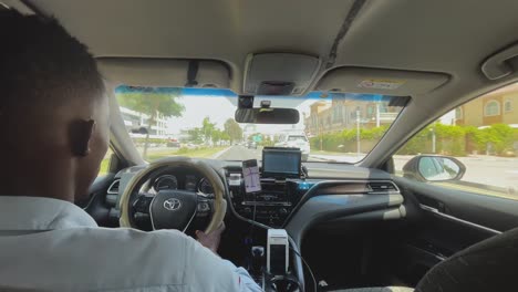 Wide-shot-of-Black-Afrcian-origin-man-driving-a-taxi-or-car-with-navigation