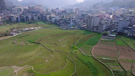 This-footage-captures-the-scenic-blend-of-rice-fields-and-a-mountain-town-in-Ha-Giang,-North-Vietnam