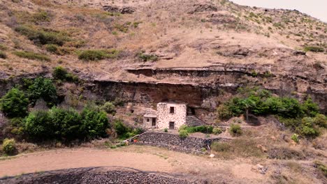 Cave-house-excavated-into-the-mountain-aerial-drone-view-of-rustic-house-in-Gran-Canaria