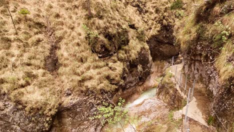 Aerial-view-of-the-Almbachklamm-waterfall-in-Garmisch-Partenkirche-during-summer-showcases-the-vibrant-display-of-colorful-foliage