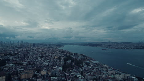 Epic-blue-hour-of-the-Istanbul-cityscape-and-the-river-with-boats,-cloudy-sky,-copy-space-and-slow-motion