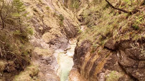 Aerial-view-of-the-Almbachklamm-waterfall-in-Garmisch-Partenkirche-during-summer-showcases-the-vibrant-display-of-colorful-foliage