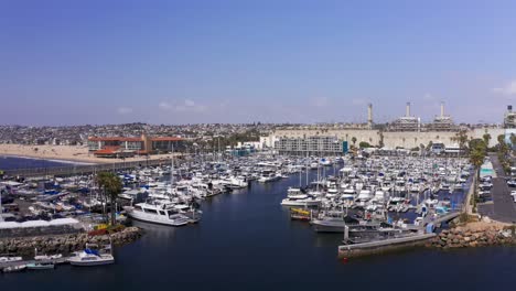 Toma-Aérea-Baja-Que-Sobrevuela-Yates-Y-Barcos-Atracados-En-El-Puerto-Deportivo-King-Harbor-En-Redondo-Beach,-California