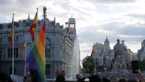 LGBTI+-demonstrator-waving-with-a-fan-at-a-parade,-symbolising-pride-and-celebration