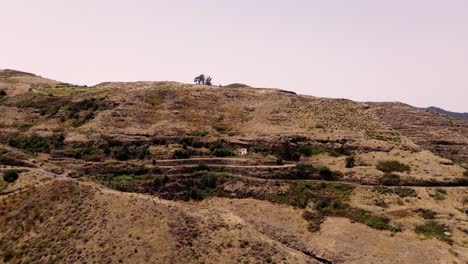 Cave-house-excavated-into-the-mountain-aerial-drone-view-of-rustic-house-in-Gran-Canaria