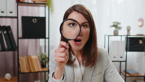 Investigator-researcher-businesswoman-looking-through-magnifying-glass-with-wow-expression-analyzing