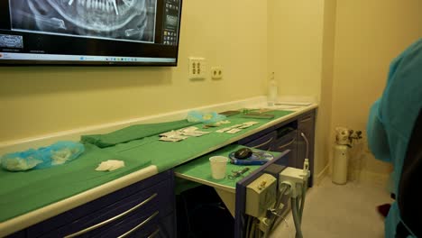 Dental-tools-arranged-on-a-table-with-an-oral-x-ray-screen-and-dentist-taking-a-saliva-ejector