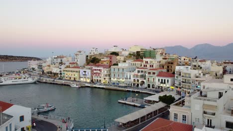 Panoramic-Flyby-Revealing-Agios-Nikolaos-City-Marina-and-Center-at-Twilight,-Crete,-Greece