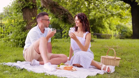 Pareja-Feliz-Con-Comida-Haciendo-Un-Picnic-En-La-Playa.-Concepto-De-Ocio,-Relaciones-Y-Personas.-Pareja-Feliz-Con-Comida-Comiendo-Uvas-Y-Haciendo-Un-Picnic-En-La-Playa.