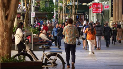 Urban-street-scene-of-downtown-Brisbane-city,-shoppers-shopping-at-Queen-street-mall,-people-strolling-at-the-outdoor-pedestrian-shopping-precinct,-slow-motion-shot