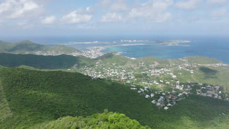 Aerial-view-capturing-beauty-of-landscape-of-Marigot,-Saint-Martin-during-daytime-with-green-mountains-in-foreground