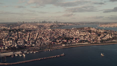 Epische-Drohnenaufnahme-Von-Istanbul-Neben-Dem-Bosporus-Zur-Goldenen-Stunde,-Stadt-Und-Fluss-In-Einem-Erstaunlichen-Licht,-Kopierraum-Und-Zeitlupe