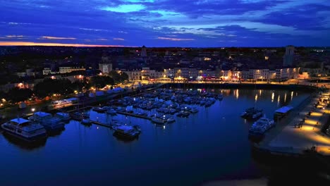 Movimiento-Aéreo-Que-Se-Acerca-Al-Puerto-Viejo-O-Vieux-Port-De-La-Rochelle-Por-La-Noche,-Francia