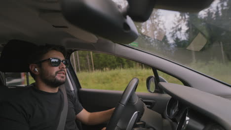 Joven-Caucásico-Conduciendo-Y-Hablando-Por-Teléfono-Con-Auriculares