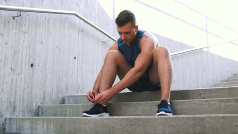 Man-Tying-Laces-of-His-Sneakers-on-Street.fitness,-sport-and-healthy-lifestyle-concept-man-tying-laces-of-his-sneakers-on-street