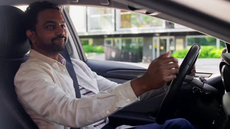 Smiling-Indian-Man-or-Driver-Driving-Car.transport,-safety-and-people-concept-happy-smiling-indian-man-or-driver-fastening-seat-belt-in-car