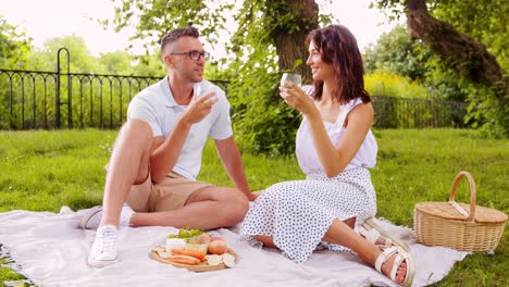 Glückliches-Paar-Mit-Essen-Beim-Picknick-Am-Strand.-Freizeit,-Beziehungen-Und-Menschen-Konzept-Glückliches-Paar-Mit-Essen,-Das-Trauben-Isst-Und-Am-Strand-Picknickt