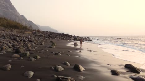 Idyllic-scene-of-a-woman-relaxing-unwinding-at-unspoiled-virgin-beach-in-Gran-Canaria,-Spain-during-summer-time-on-vacations