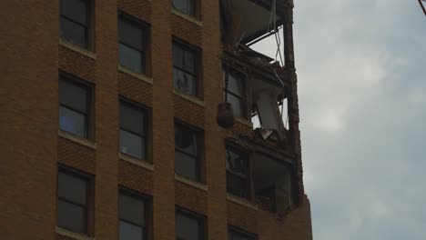 A-wrecking-ball-swings-into-a-high-rise-building-during-its-demolition-in-Youngstown,-Ohio,-showing-significant-structural-damage-and-exposed-interior-sections