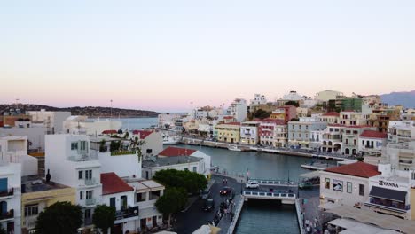 Vuelo-Sobre-El-Lago-Voulisméni-Y-La-Ciudad-Costera-De-Agios-Nikolaos,-Isla-De-Creta,-Grecia