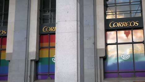 Correos-building-in-Madrid-adorned-with-pride-decorations,-showcasing-support-for-LGBTQ+-community