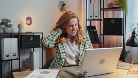 Business-woman-suffers-from-spine-neck-muscle-pain-at-home-office-workplace-working-on-laptop