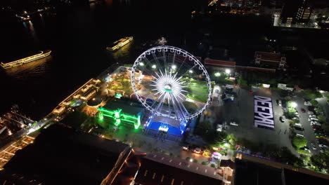 Aerial-view-around-the-night-lit-Asiatique-Sky-Ferris-Wheel-in-Bangkok,-Thailand