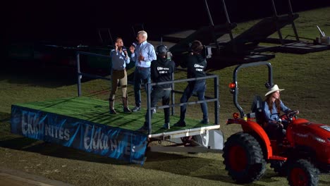 Ekka-Nites,-Eine-Jährliche-Traditionelle-Abendveranstaltung-Mit-Moderatoren-Auf-Der-Bühne,-Die-Einen-Roten-Traktor-über-Die-Hauptarena-Des-Brisbane-Showgrounds-Ziehen