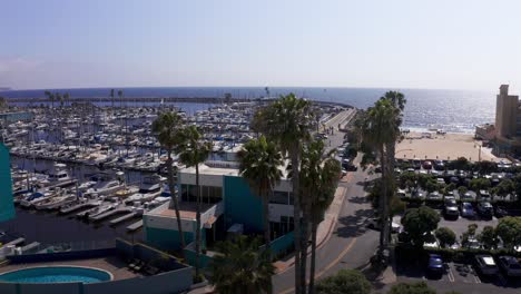 Aerial-low-panning-shot-of-the-admin-building-at-King-Harbor-Marina-in-Redondo-Beach,-California