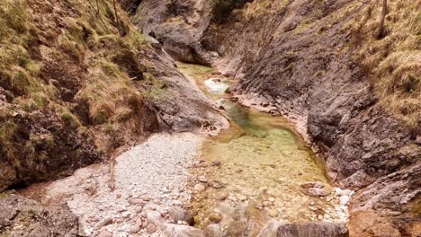 Aerial-view-of-the-Almbachklamm-waterfall-in-Garmisch-Partenkirche-during-summer-showcases-the-vibrant-display-of-colorful-foliage