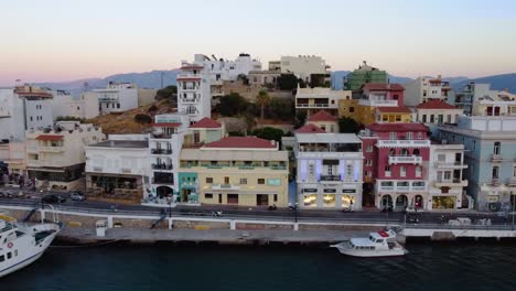 Aerial-Slide-Shot-of-Agios-Nikolaos-Town-Marginal-Road-and-Marina,-Crete,-Greece