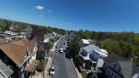 First-point-view-flight-over-street-with-single-family-homes-at-bright-sunny-day