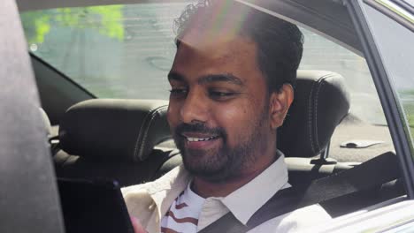 Indian-Male-Passenger-with-Tablet-Pc-in-Taxi-Car.transportation,-vehicle-and-people-concept-smiling-indian-male-passenger-with-tablet-pc-computer-in-taxi-car