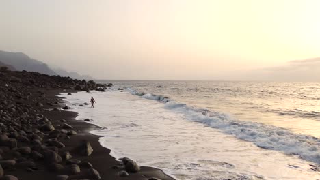 Idyllic-scene-of-a-woman-relaxing-unwinding-at-unspoiled-virgin-beach-in-Gran-Canaria,-Spain-during-summer-time-on-vacations