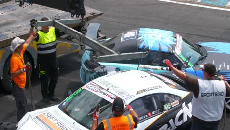 Preparing-to-lift-one-of-the-crashed-cars-so-it-can-be-removed-from-the-racing-tracks-1