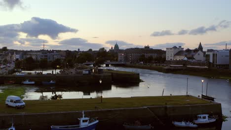 Aerial-descending-shot-of-Galway-city-at-twilight-from-the-Claddagh-docks