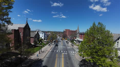 Drone-flight-over-main-street-of-american-town-with-houses-and-buildings