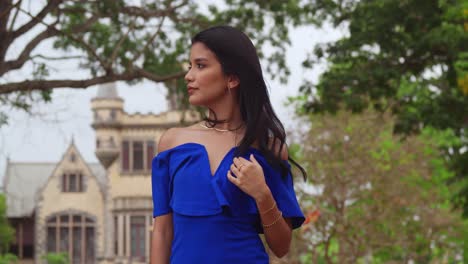 A-girl-in-a-blue-dress-enjoys-a-sunny-park-with-castles-in-the-background