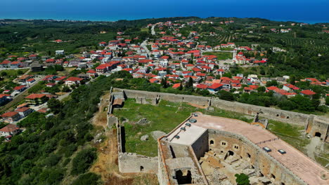 Aerial-view-of-the-Chlemoutsi-Castle-Museum-and-the-town-Kastro-with-red-rooftops-in-Greece,-slow-motion-and-copy-space