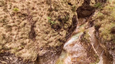 Aerial-view-of-the-Almbachklamm-waterfall-in-Garmisch-Partenkirche-during-summer-showcases-the-vibrant-display-of-colorful-foliage