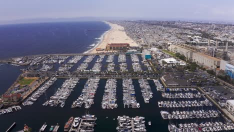 Aerial-wide-panning-shot-of-the-King-Harbor-Marina-towards-Hermosa-Beach-in-Redondo-Beach,-California