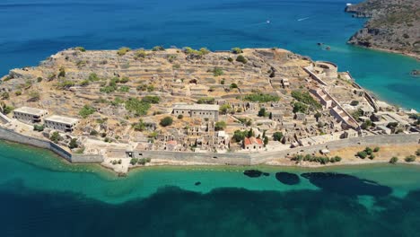 Annäherung-An-Die-Luftaufnahme-Der-Antiken-Venezianischen-Festungsinsel-Spinalonga-Und-Des-Türkisfarbenen-Wassers,-Griechenland