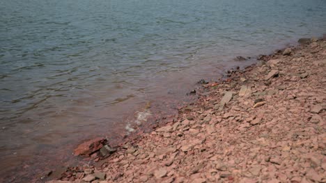 Pequeñas-Olas-De-Agua-Rompiendo-En-La-Orilla-De-Un-Lago