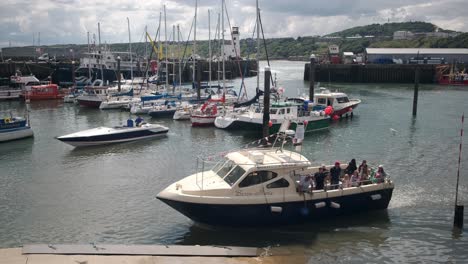 footage-of-Scarborough-Harbour,-North-Yorkshire-on-a-summer-day-the-harbor-has-boats-and-people-walking-around