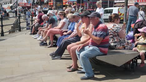 footage-of-Scarborough,-people-eating-icecream-on-a-summer-day-on-a-busy-weekend-with-families-enjoying-the-English-coastal-seaside-resort