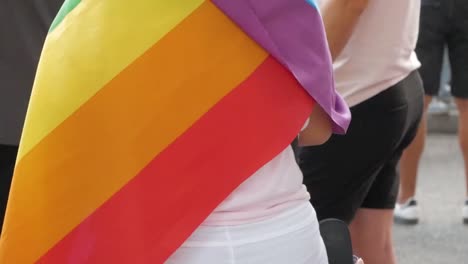 Person-holding-a-pride-flag-and-a-man-smoking-a-cigarette