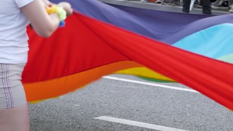 Giant-rainbow-flag-being-carried,-symbolising-pride-and-unity